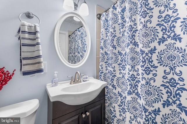 bathroom featuring a shower with curtain, vanity, and toilet