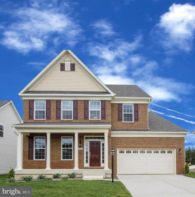 view of front of house featuring a porch, a garage, and a front lawn