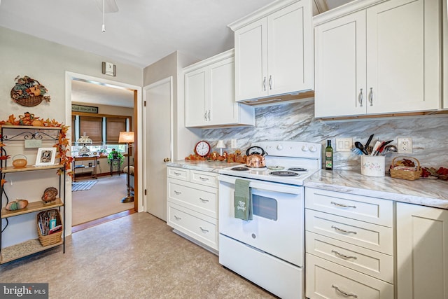 kitchen featuring electric stove, light stone countertops, white cabinets, and decorative backsplash