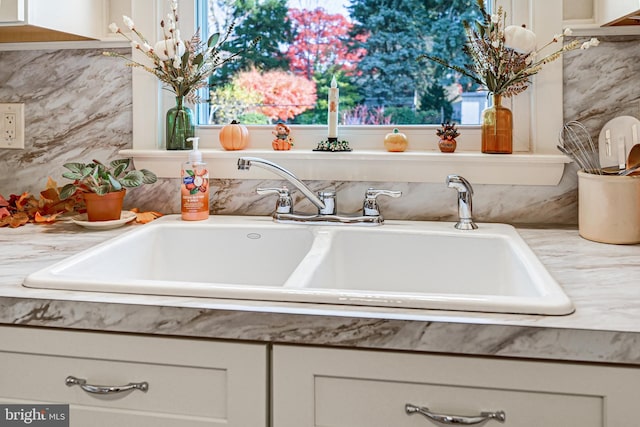 interior details featuring white cabinetry and sink