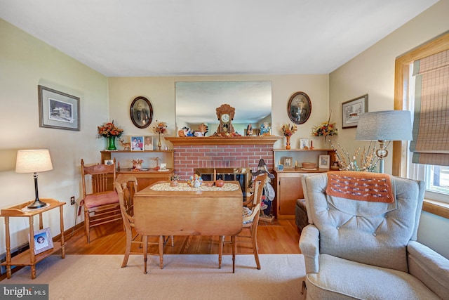 dining space featuring a fireplace and light hardwood / wood-style flooring