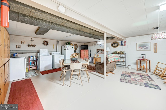 dining space featuring concrete floors and washing machine and clothes dryer