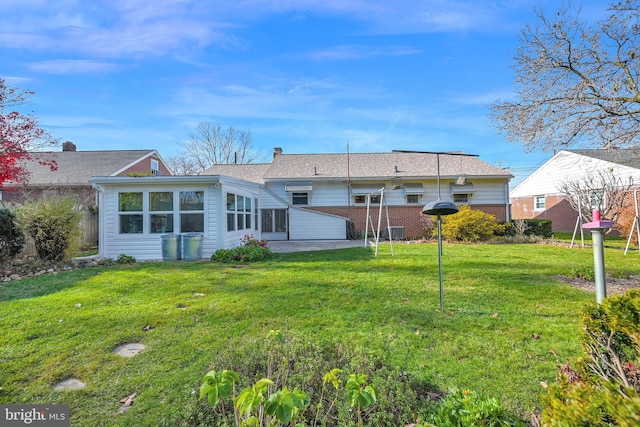 back of house with a yard and a patio