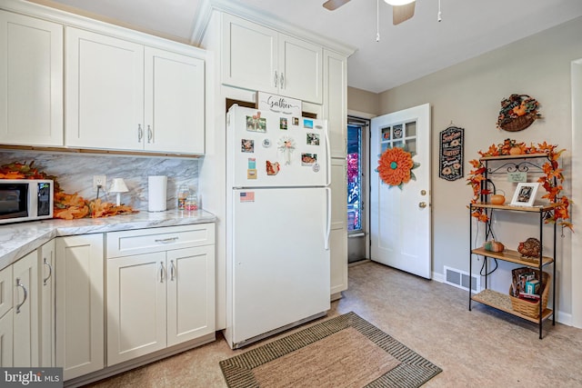 kitchen featuring white cabinets, ceiling fan, white refrigerator, and backsplash