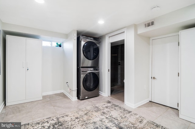 laundry room featuring stacked washer / drying machine