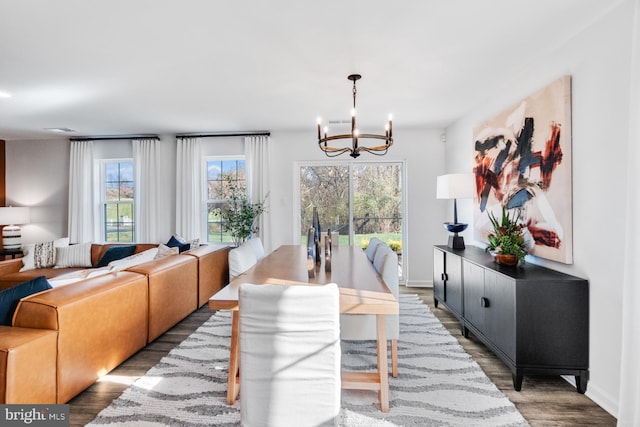 dining area featuring hardwood / wood-style flooring and an inviting chandelier