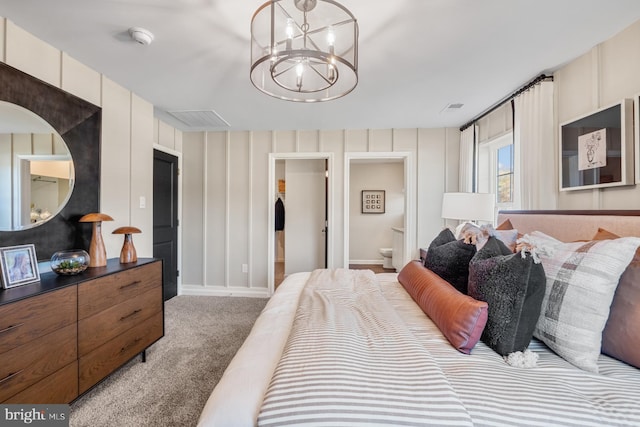 bedroom featuring carpet floors, ensuite bathroom, and an inviting chandelier