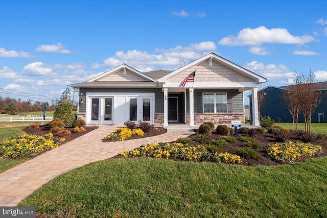 craftsman inspired home with french doors and a front yard