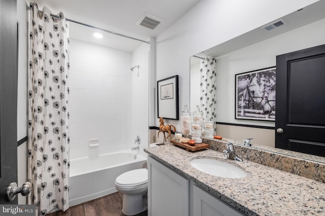 full bathroom with vanity, hardwood / wood-style flooring, toilet, and shower / bath combo with shower curtain