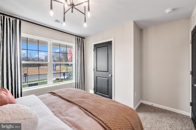 carpeted bedroom with multiple windows and an inviting chandelier