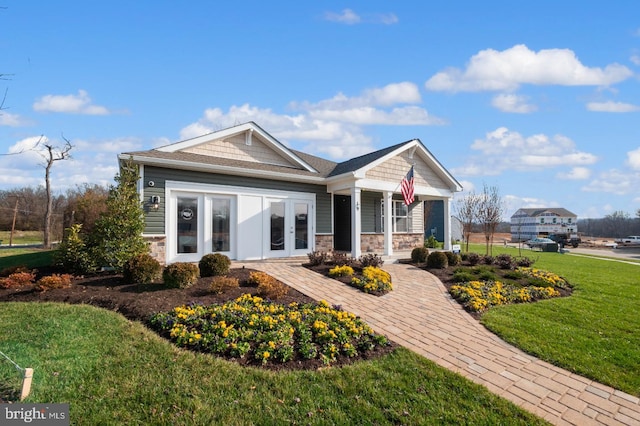 view of front of property with covered porch, a front yard, and french doors