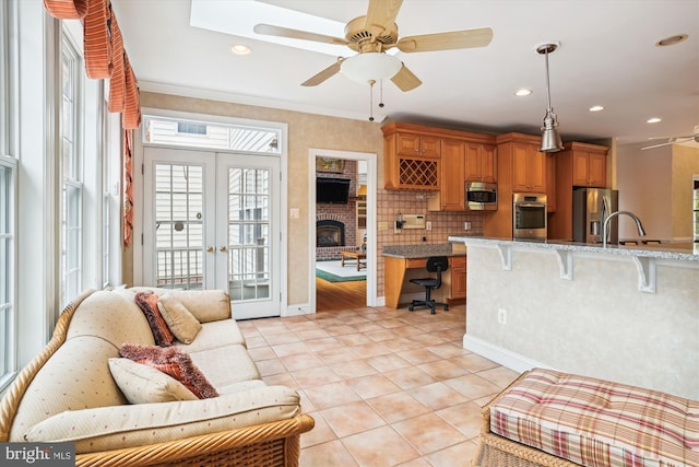 living room featuring ceiling fan, light tile patterned flooring, ornamental molding, and french doors