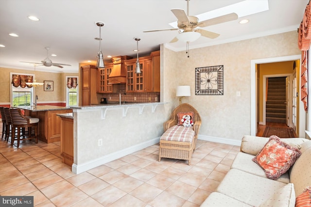 kitchen featuring a kitchen breakfast bar, premium range hood, kitchen peninsula, pendant lighting, and stone countertops