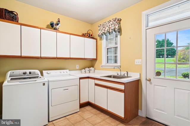 laundry area featuring washing machine and dryer, sink, and cabinets