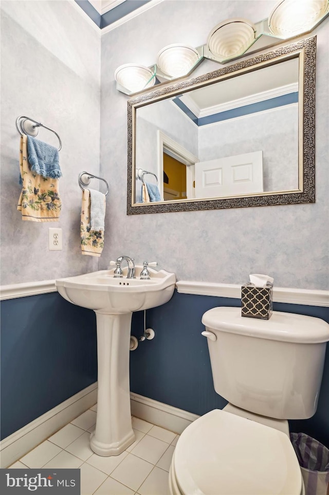 bathroom with tile patterned floors, toilet, and ornamental molding