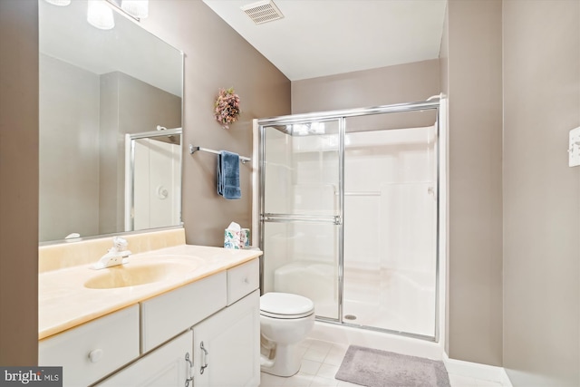 bathroom featuring toilet, vanity, tile patterned floors, and a shower with shower door