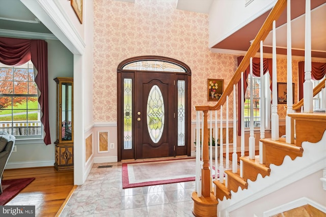 entrance foyer with a towering ceiling, hardwood / wood-style flooring, and a wealth of natural light