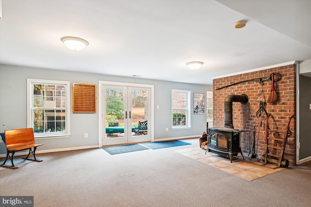 living room featuring light carpet, french doors, and a wood stove