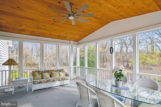 unfurnished sunroom with ceiling fan, a healthy amount of sunlight, wood ceiling, and vaulted ceiling