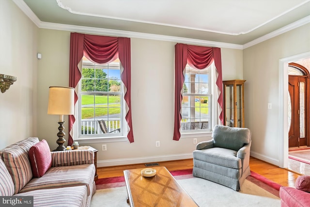 sitting room with hardwood / wood-style floors, a wealth of natural light, and crown molding