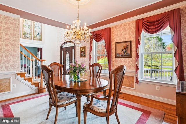 dining room with crown molding, hardwood / wood-style floors, and a chandelier