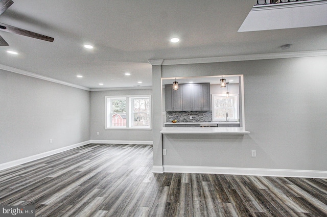 unfurnished living room with dark hardwood / wood-style floors, ceiling fan, sink, and crown molding