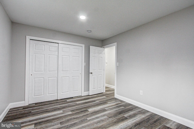 unfurnished bedroom featuring dark hardwood / wood-style floors and a closet