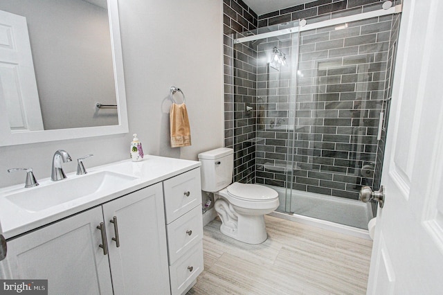 bathroom with vanity, toilet, and an enclosed shower