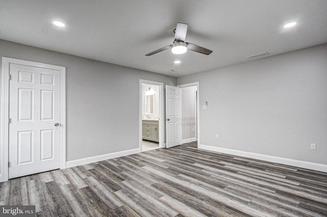 unfurnished bedroom featuring hardwood / wood-style floors, ensuite bath, and ceiling fan