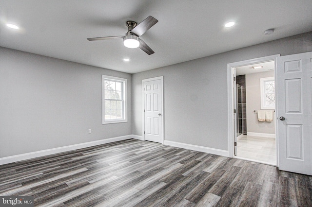 unfurnished bedroom with a closet, dark hardwood / wood-style floors, ensuite bath, and ceiling fan