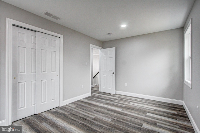 unfurnished bedroom with a closet and hardwood / wood-style floors