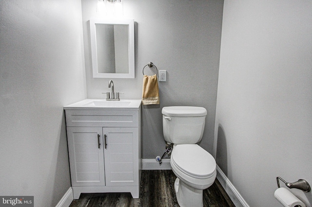 bathroom featuring toilet, vanity, and hardwood / wood-style flooring