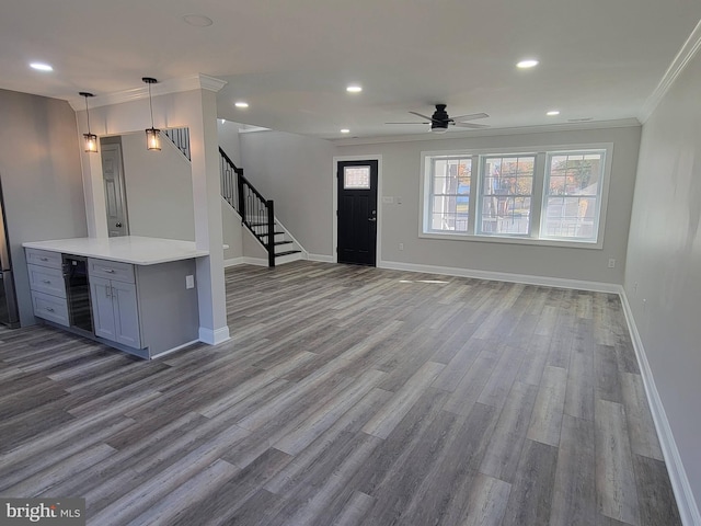 kitchen with hardwood / wood-style floors, crown molding, ceiling fan, decorative light fixtures, and beverage cooler