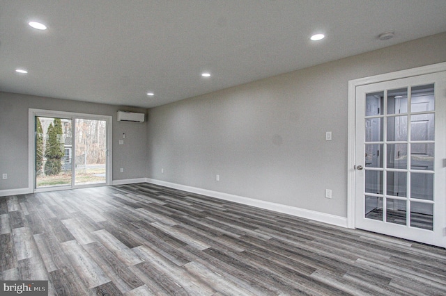 empty room featuring hardwood / wood-style floors and an AC wall unit