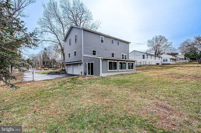 back of house featuring a garage and a yard