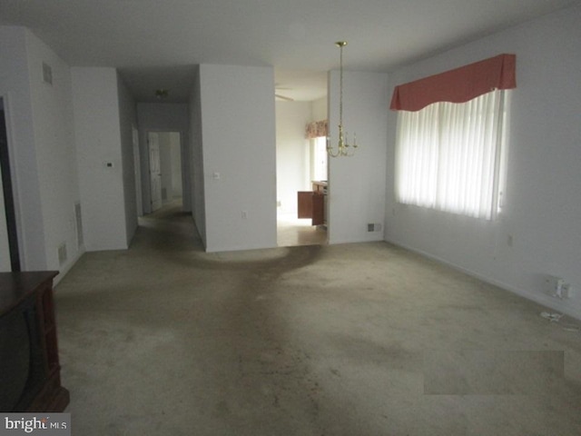 interior space with carpet floors and an inviting chandelier