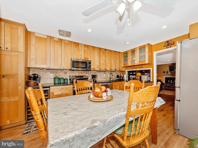 dining area featuring ceiling fan, light hardwood / wood-style floors, and sink