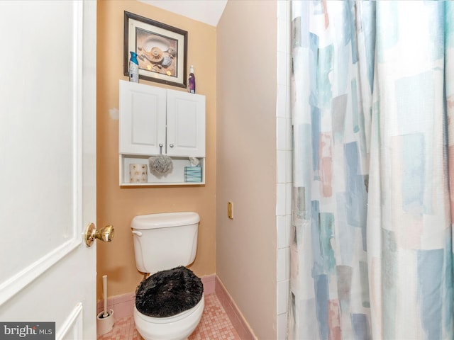 bathroom with toilet, a shower with curtain, and tile patterned floors