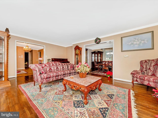 living room with a chandelier, wood-type flooring, and crown molding