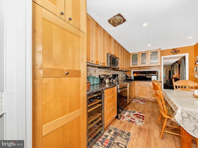 kitchen with light brown cabinets, wine cooler, light hardwood / wood-style flooring, decorative backsplash, and appliances with stainless steel finishes