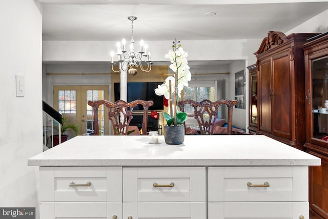 8111 Bird Ln, Greenbelt, MD 20770 - kitchen featuring a chandelier, light stone counters, french doors, and white cabinetry