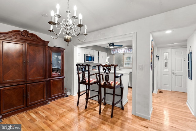 8111 Bird Ln, Greenbelt, MD 20770 - dining area featuring light wood-style flooring, ceiling fan, and a chandelier