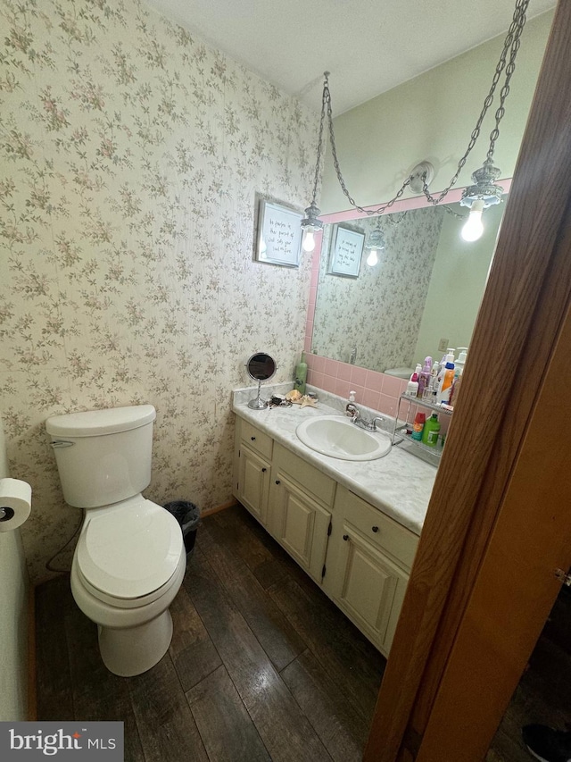 bathroom featuring hardwood / wood-style flooring, vanity, toilet, and a textured ceiling