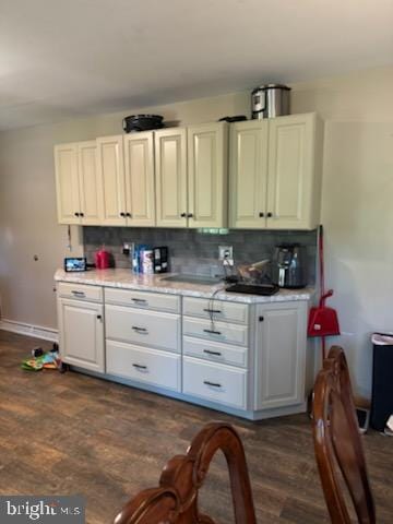 kitchen with white cabinets, dark hardwood / wood-style flooring, and tasteful backsplash