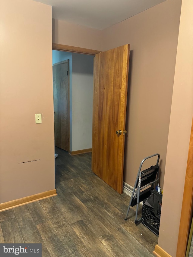 unfurnished room with dark wood-type flooring