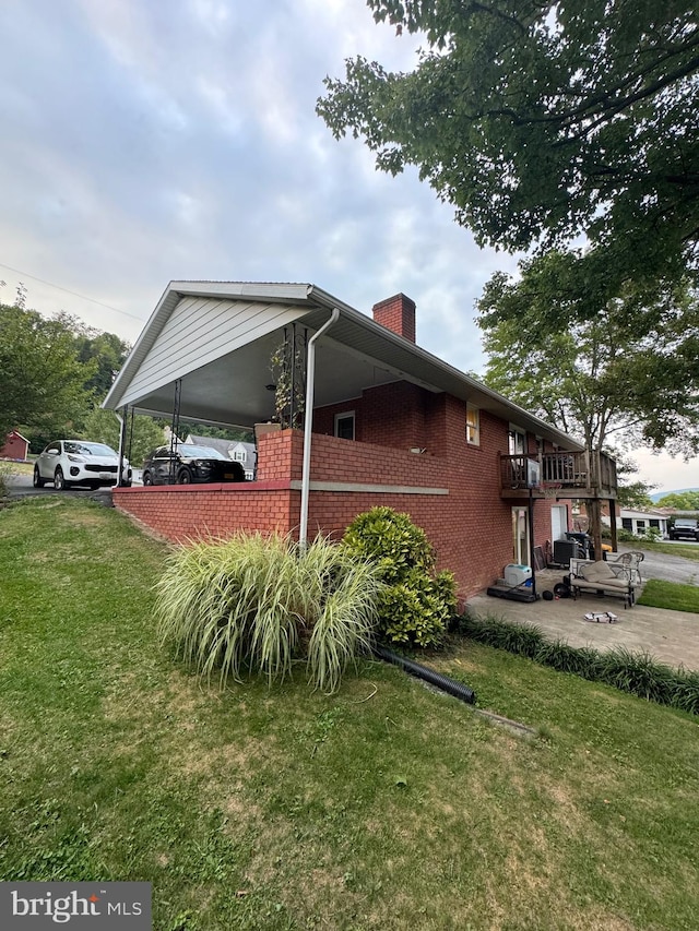 view of side of home with a carport and a lawn