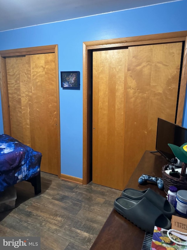 bedroom with dark hardwood / wood-style floors and a closet