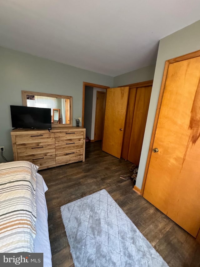 bedroom with dark hardwood / wood-style flooring