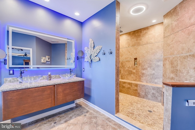 bathroom with vanity and tiled shower