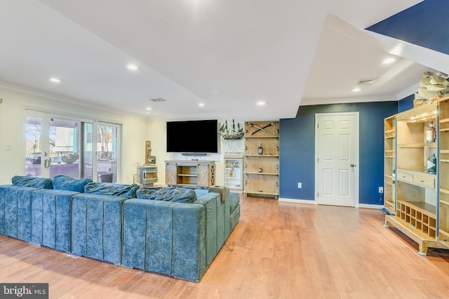 living room featuring light wood-type flooring and ornamental molding